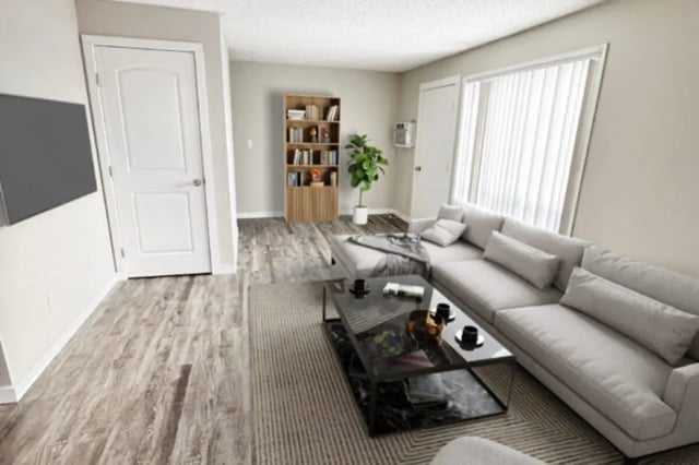 Sectional sofa, coffee table, bookcase, plant living room at Cougar Ridge Apartments in Pullman Student Accommodation