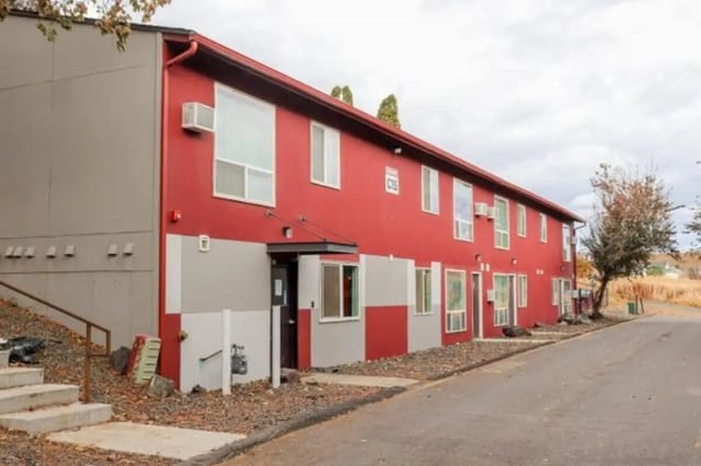 Modern red and grey building with windows exterior at Cougar Ridge Apartments in Pullman Student Accommodation