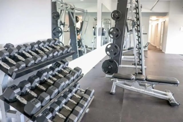 Dumbbell racks weight plates weight bench gym area at Cougar Ridge Apartments in Pullman Student Accommodation