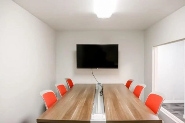 Conference table with chairs and wall mounted TV Meeting room at Cougar Ridge Apartments in Pullman Student Accommodation