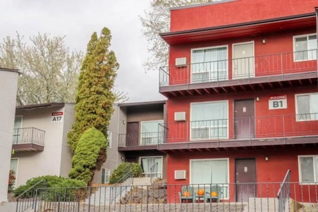 Red building with balconies and chairs exterior at Cougar Ridge Apartments in Pullman Student Accommodation