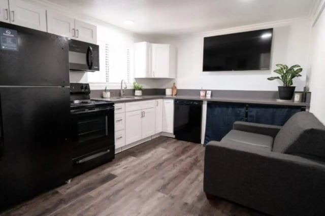 Kitchen area with black appliances sofa living room at Glenwood Apartments in Provo Student Accommodation