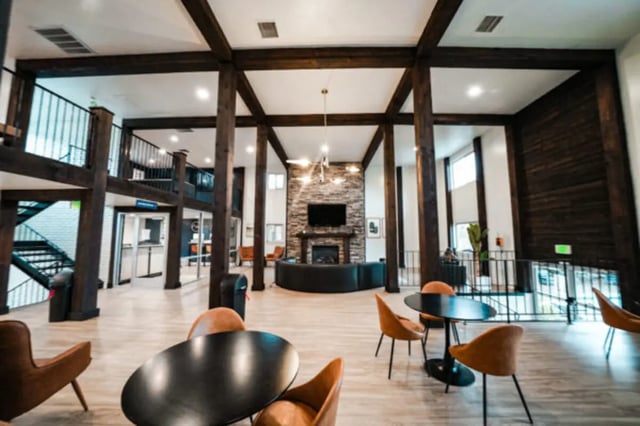 Lounge with fireplace seating dining tables staircase exterior at Glenwood Apartments in Provo Student Accommodation
