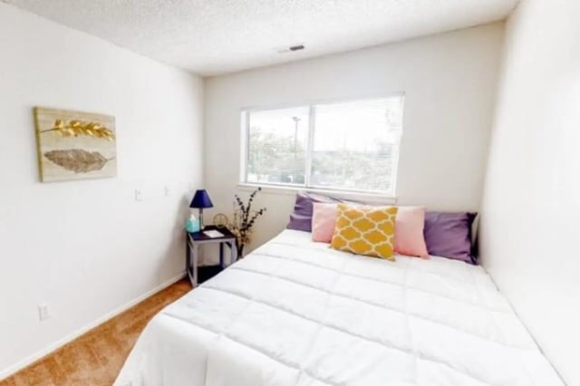 Bed with pillows nightstand and artwork bedroom at Apple Lane Apartments in Lawrence Student Accommodation