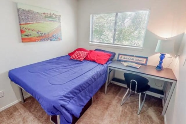 Bed with blue covers and pillows desk chair bedroom at Apple Lane Apartments in Lawrence Student Accommodation