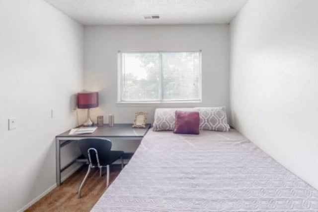 Desk lamp chair bed and pillows bedroom at Apple Lane Apartments in Lawrence Student Accommodation