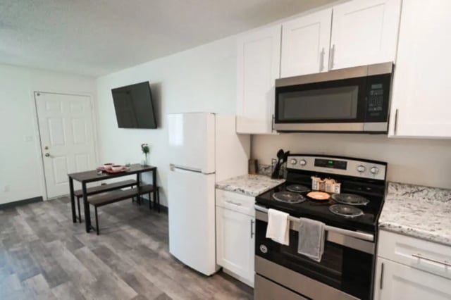 Dining table refrigerator stove microwave kitchen at Apple Lane Apartments in Lawrence Student Accommodation