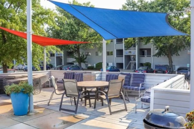 Outdoor seating area with blue and red shade sails exterior at Apple Lane Apartments in Lawrence Student Accommodation