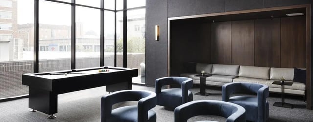 Pool table blue chairs sofa lounge area at The M Seattle in Seattle Student Accommodation