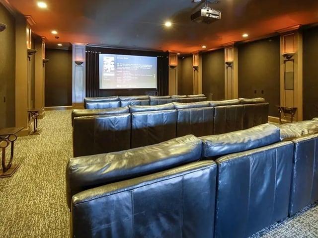 Tiered black leather couches facing projector screen Cinema room at The Province in Louisville Student Accommodation