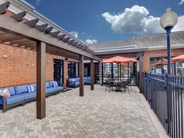 Blue sofas outdoor table under umbrella patio exterior at The Province in Louisville Student Accommodation