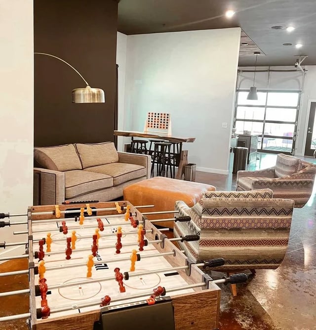 Foosball table couches ottoman chairs bar living room at Fireside District Apartments in Stephenville Student Accommodation