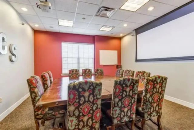 Conference room with projector screen and chairs at Campus Village Apartments in College Station Student Accommodation