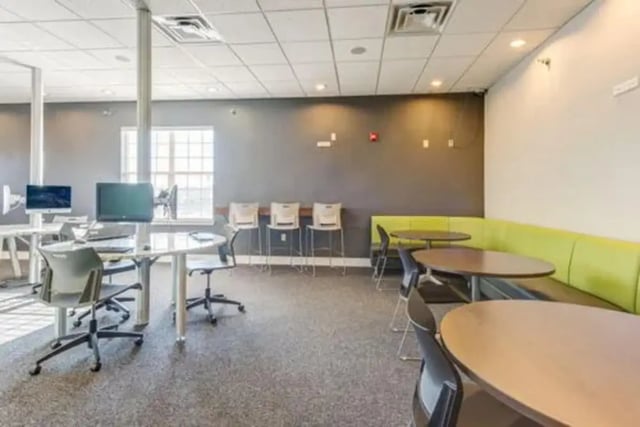 Computers tables chairs and green booths common area at Campus Village Apartments in College Station Student Accommodation