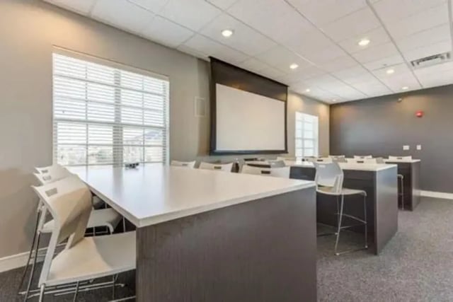 White tables chairs projector screen common area at Campus Village Apartments in College Station Student Accommodation