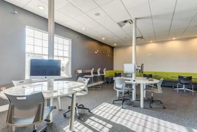 Computers desks chairs and green banquette seating study area at Campus Village Apartments in College Station Student Accommodation