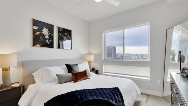 Bed with pillows dark throw window view bedroom at The Dorsey in Denver Student Accommodation