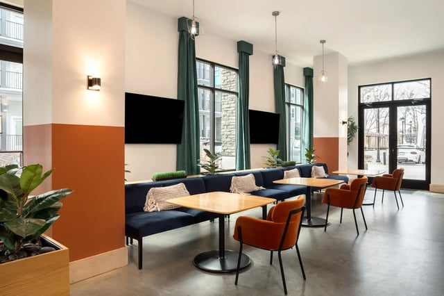 Modern lounge with blue seating and orange chairs at Dockside Clemson in Clemson Student Accommodation