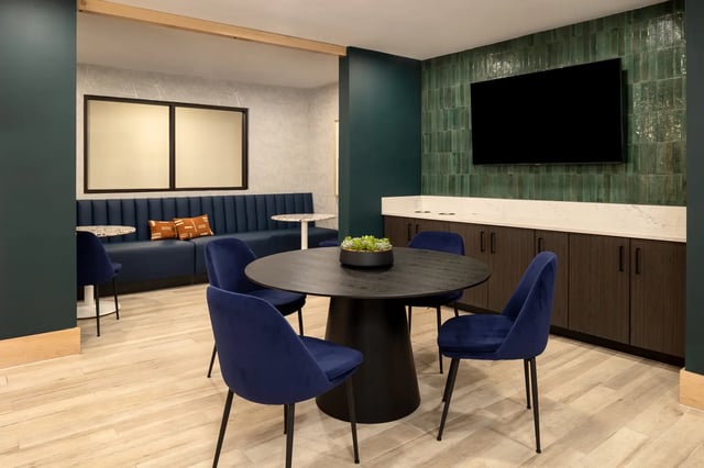 Round table blue chairs dark cabinets living room at Dockside Clemson in Clemson Student Accommodation