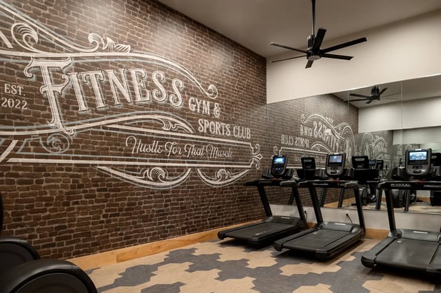 Treadmills against brick wall with fitness decor Gym at Dockside Clemson in Clemson Student Accommodation