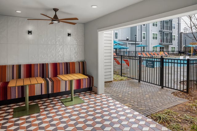 Striped banquette two tables pool area exterior at Dockside Clemson in Clemson Student Accommodation