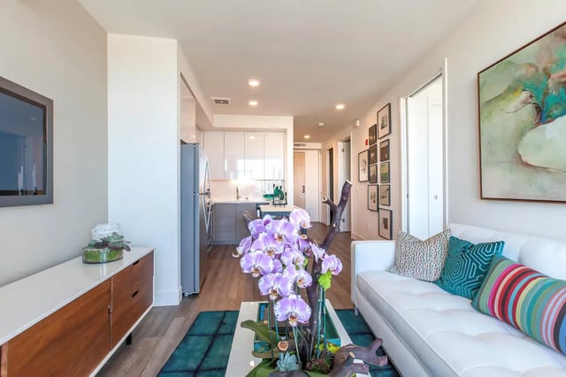 White sofa orchid arrangement artwork kitchen living room at The Dwight by Arthaus in Berkeley Student Accommodation