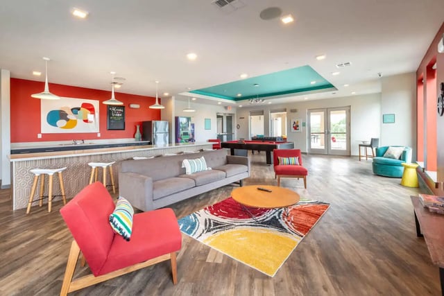 Sofa pool table bar stools kitchen living area at Campus Vue Apartments in Houston Student Accommodation