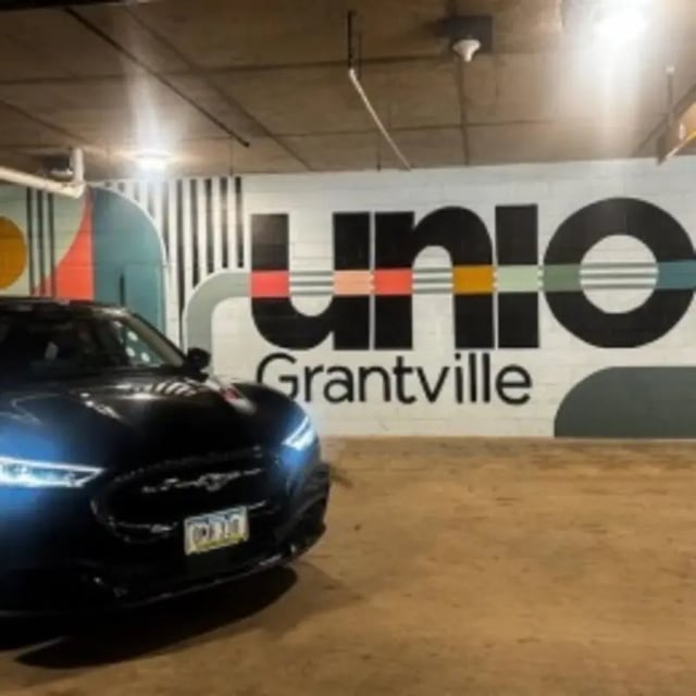 Black car parked in front of Union Grantville mural parking exterior at Union Grantville in San Diego Student Accommodation