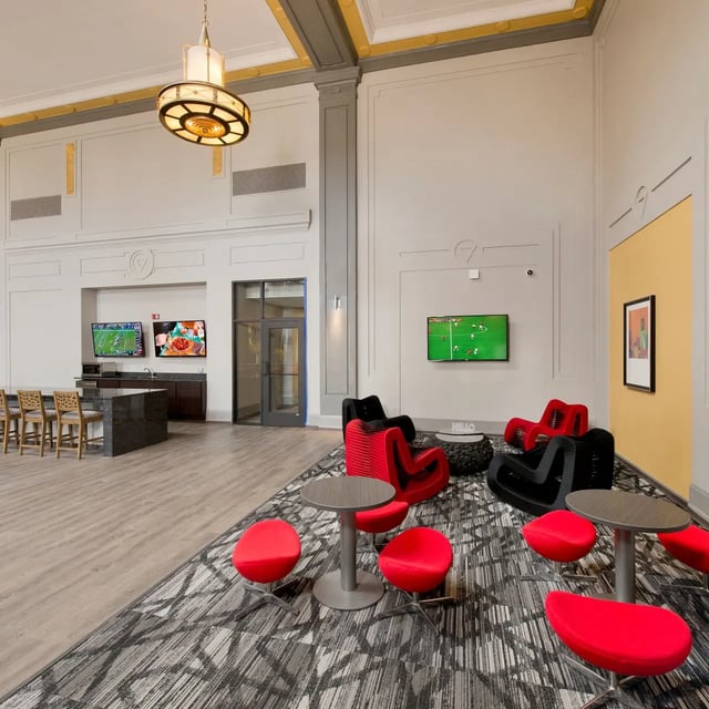 Lounge seating with TVs and kitchen area lounge at Domain at Cleveland in Cleveland Student Accommodation