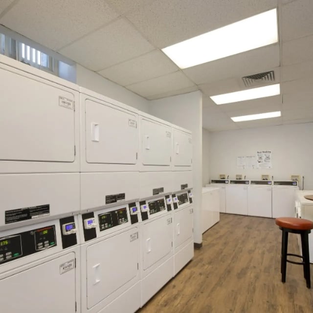 Stackable white dryers and washers with control panels Laundry Room at Domain at Cleveland in Cleveland Student Accommodation