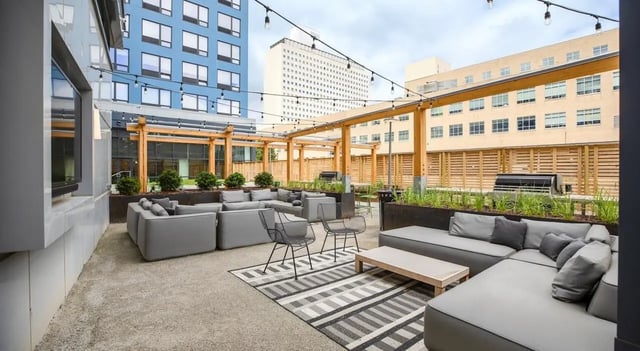 Grey sofas grills string lights and wooden pergolas outdoor area at The Hamilton in Philadelphia Student Accommodation