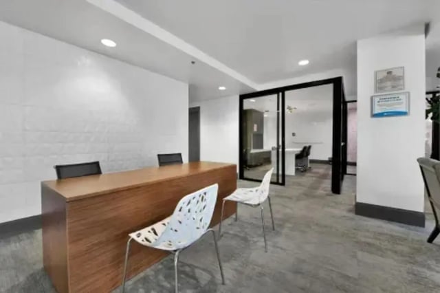 Desk with chairs and glass partition coworking space at GrandMarc Austin in Austin Student Accommodation