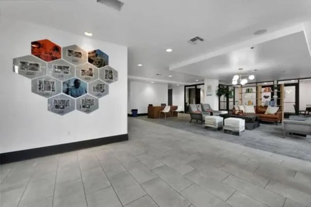 Hexagonal photos on wall lounge seating and tables common area at GrandMarc Austin in Austin Student Accommodation