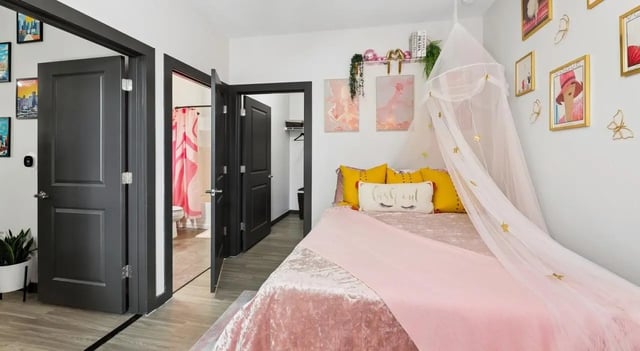 Pink bed with canopy yellow pillows bedroom at The Local Downtown in San Marcos Student Accommodation