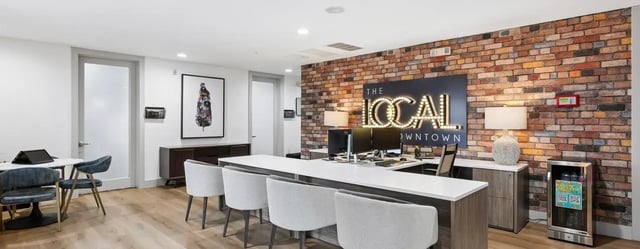 Reception desk with chairs and computers lounge area at The Local Downtown in San Marcos Student Accommodation