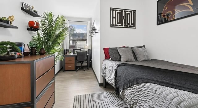 Bed dresser desk and plants bedroom and study area at The Local Downtown in San Marcos Student Accommodation