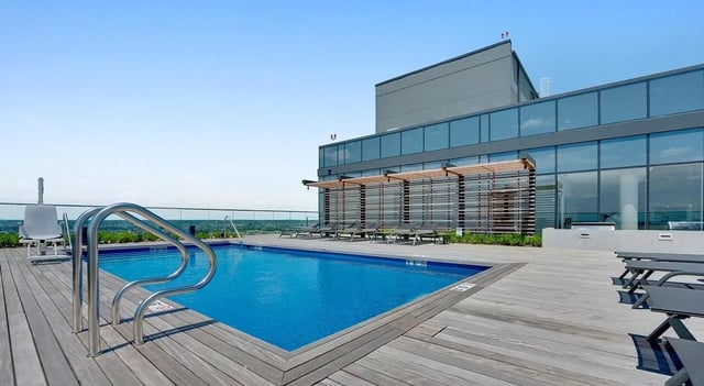 Rooftop pool with lounge chairs and building exterior view at The Chestnut in Philadelphia Student Accommodation