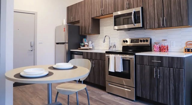 Round table microwave refrigerator stove cabinets kitchen at Legacy202 Apartments in Champaign Student Accommodation