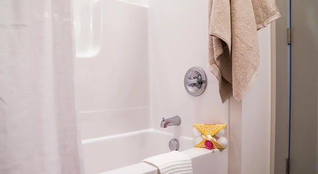 White bathtub faucet shower curtain towel bath bombs bathroom at Legacy202 Apartments in Champaign Student Accommodation