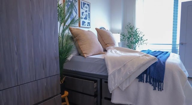 Bed with pillows and blue throw bedroom at Legacy202 Apartments in Champaign Student Accommodation