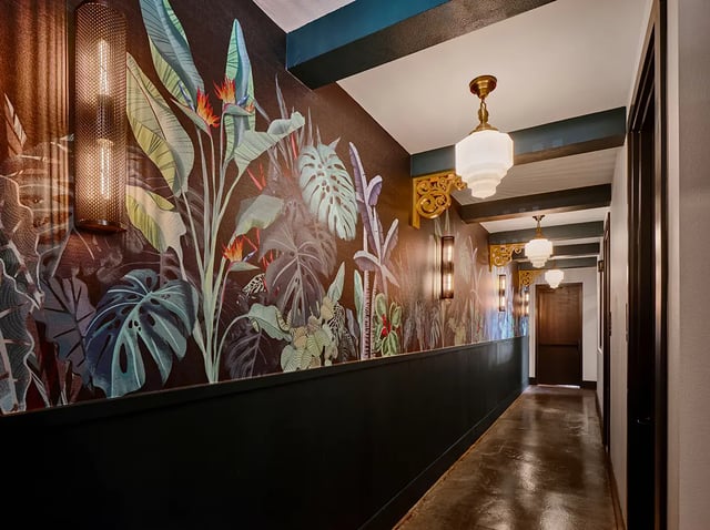 Tropical wallpaper wall sconces pendant lights hallway at Flatiron in Baton Rouge Student Accommodation