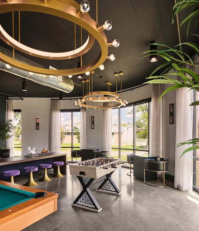 Pool table foosball table bar stools living room at Flatiron in Baton Rouge Student Accommodation
