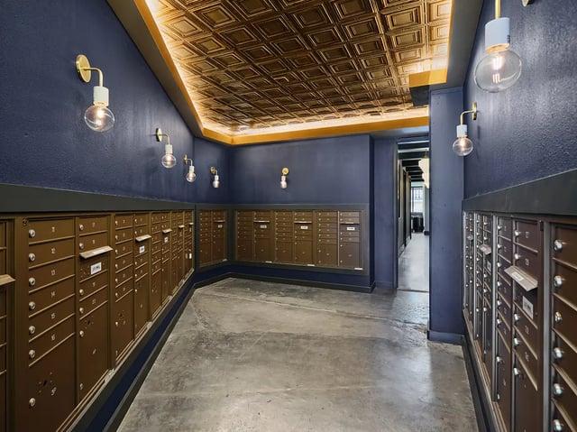 Mailboxes with golden ceiling and sconces entryway at Flatiron in Baton Rouge Student Accommodation