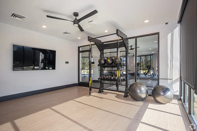 Gym equipment exercise balls and television room at Flatiron in Baton Rouge Student Accommodation