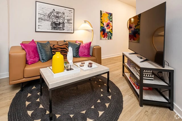 Brown sofa colorful pillows coffee table TV living room at Flatiron in Baton Rouge Student Accommodation