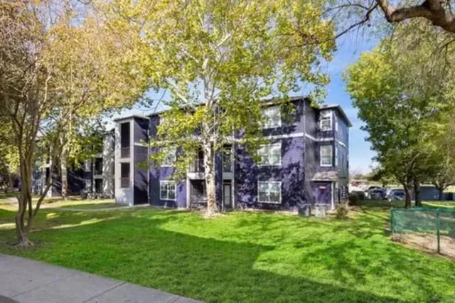 Purple apartment building with green lawn exterior at Mirage San Marcos in San Marcos Student Accommodation