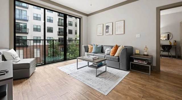 Grey sofa coffee table rug with balcony exterior living room at Accolade Athens in Athens Student Accommodation