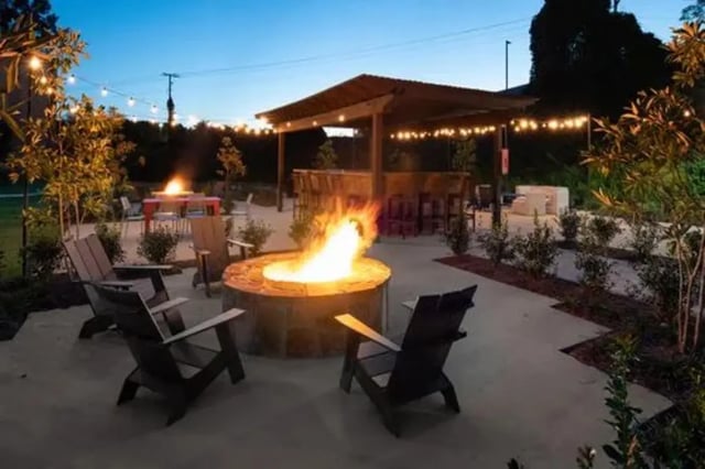 Fire pit chairs covered patio bar lights exterior at Flatts at South Campus in Oxford Student Accommodation