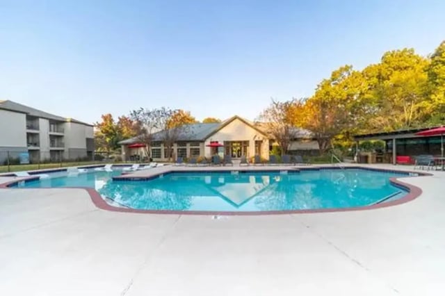 Apartment complex with pool lounge chairs and clubhouse exterior at Flatts at South Campus in Oxford Student Accommodation