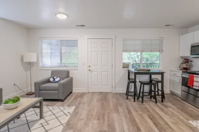 Armchair coffee table and kitchen area living room at Fleur De Lis Apartments in Provo Student Accommodation
